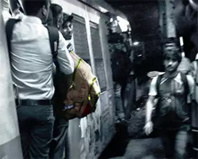 A man traveling with a bag on his chest in a crowded local train, putting himself at risk of serious injury or death.