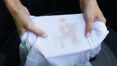 A person removing a stubborn stain from their clothes using a home remedy
