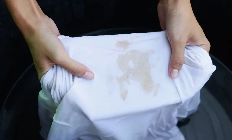 A person removing a stubborn stain from their clothes using a home remedy