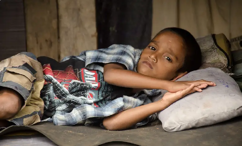 A group of homeless children in India sitting on the side of a road, looking sad and lost