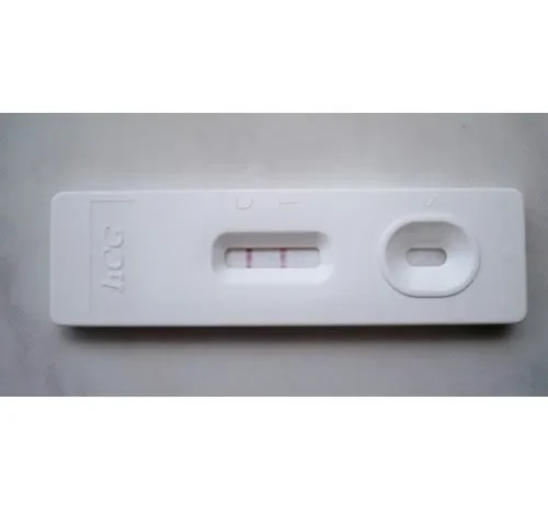A woman holding a pregnancy test kit and looking at the results.