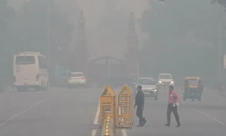 A photo of Delhi's skyline shrouded in smog, with a team of workers in masks and gloves cleaning up a street