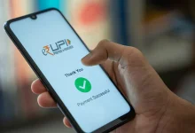 A person in Uttar Pradesh using a mobile phone to make a digital payment at a shop.