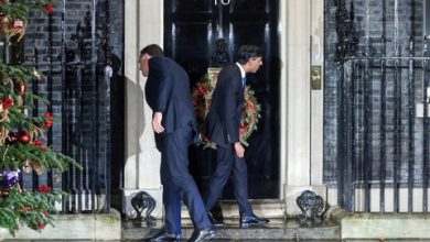 British Prime Minister Rishi Sunak stands confused outside 10 Downing Street, unable to open the door."