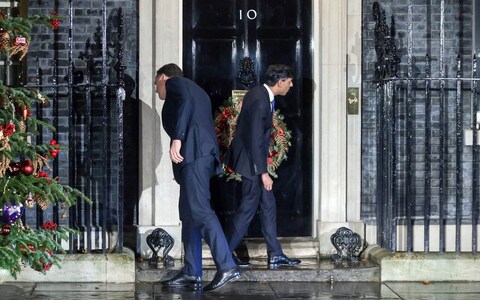 British Prime Minister Rishi Sunak stands confused outside 10 Downing Street, unable to open the door."