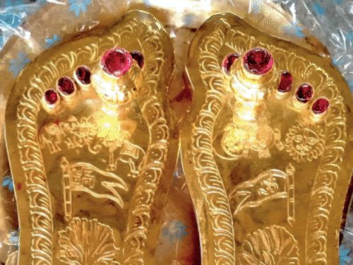 A close-up view of Lord Ramlala's ornate charan paduka, adorned with gold and silver.