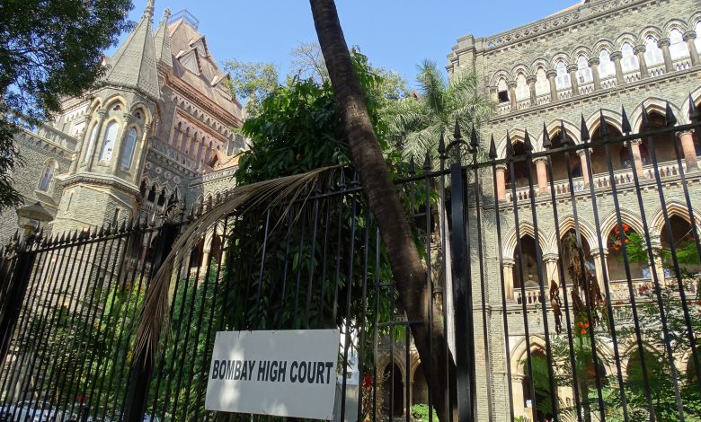 A gavel rests on a law book with a blurred background of the Bombay High Court building, representing the limitations of free speech in India.