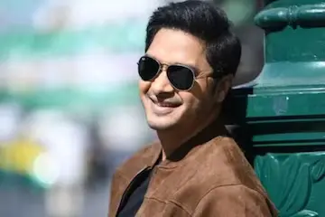 Shreyas Talpade smiling and talking in a hospital room, looking optimistic after his recent heart attack.