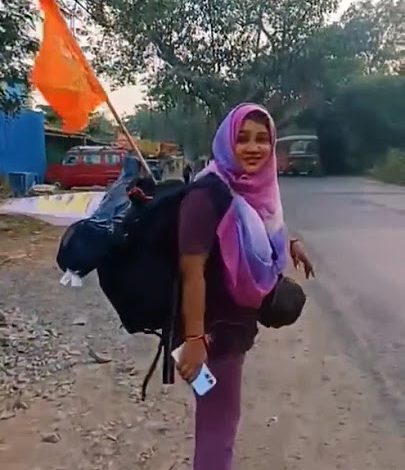 A young Muslim woman wearing a hijab and draped in a saffron shawl walks towards the Ayodhya temple, symbolizing India's interfaith harmony.