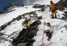 A panoramic view of Mount Everest with a traditional sky burial ceremony taking place on the mountain peak.