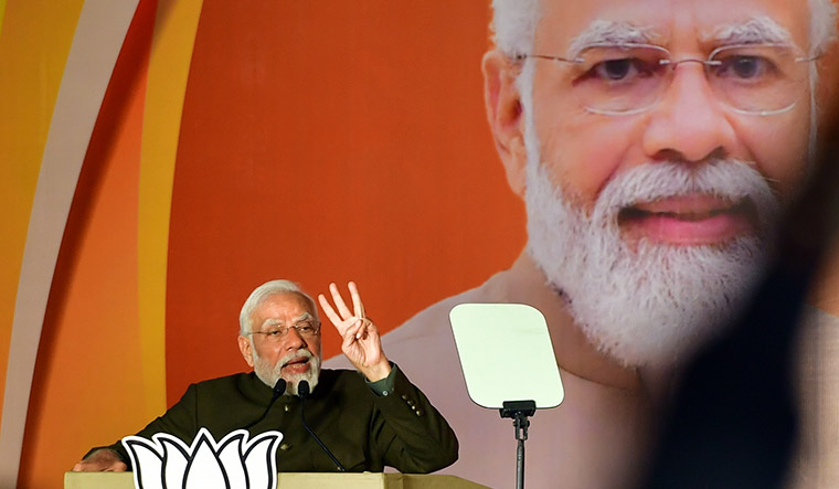 Narendra Modi addressing a rally under a saffron banner, highlighting BJP's focus on Hindu identity politics for upcoming elections.