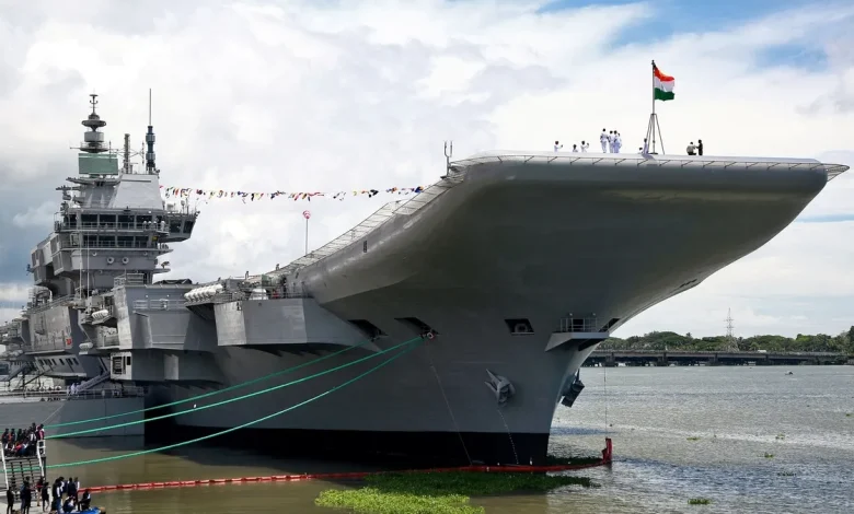 A photorealistic depiction of the Indian Navy aircraft carrier INS Vikrant launching a volley of MR-SAM missiles, with the Indian flag fluttering in the background. The image should convey a sense of power, precision, and technological advancement.