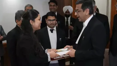 Chief Justice of India presenting an award to the daughter of a Supreme Court cook, with a background of the Supreme Court building
