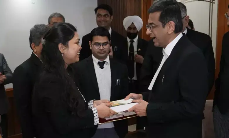 Chief Justice of India presenting an award to the daughter of a Supreme Court cook, with a background of the Supreme Court building