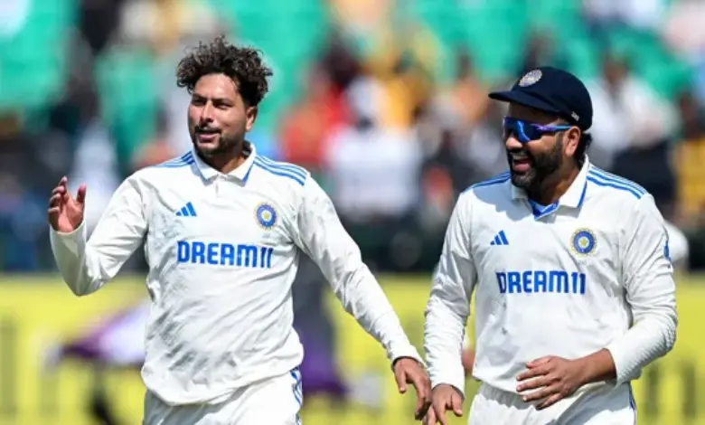 India's Kuldeep Yadav celebrates with his captain Rohit Sharma (R) after taking the wicket of England's captain Ben Stokes