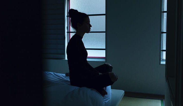 sitting-on-bed-in-dark-room