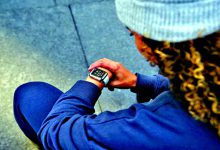 Young people using smartwatches during outdoor activities