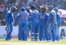 Jasprit Bumrah and Varun Chakravarthy in cricket jerseys during Champions Trophy match.