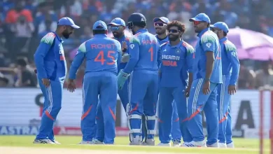 Jasprit Bumrah and Varun Chakravarthy in cricket jerseys during Champions Trophy match.