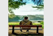 Person meditating peacefully in a natural setting, symbolizing slow living philosophy.