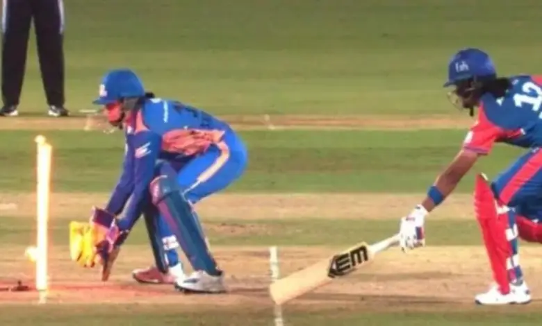 LED stumps light up during WPL match as umpire reviews run-out decision between Delhi Capitals and Mumbai Indians.