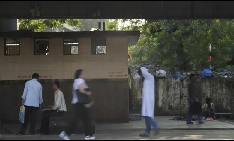 "A surveyor inspecting a clean toilet facility at a busy railway station, ensuring high sanitation standards."