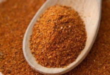 Person adding Buknu spice to food for digestive health