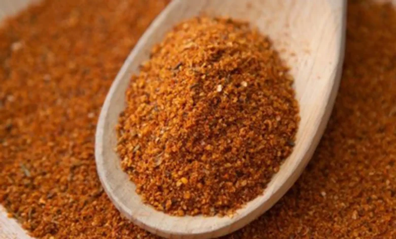 Person adding Buknu spice to food for digestive health