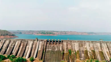 Low water levels in Mumbai reservoirs with cityscape in background