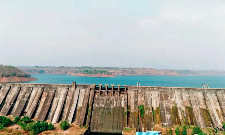 Low water levels in Mumbai reservoirs with cityscape in background