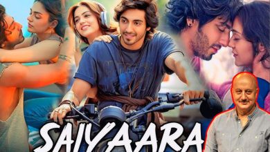 અનુપમ ખેર પાછળ ફિલ્મનું પોસ્ટર.