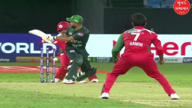 પાકિસ્તાન અને ઓમાનના ખેલાડીઓ ક્રિકેટના મેદાન પર મેચ રમતા જોવા મળે છે, પાછળ દુબઈનું સ્ટેડિયમ છે.