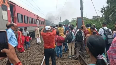 ઝારખંડના જામતાડામાં ટ્રેનના કોચમાં લાગેલી આગ. રેલવે કર્મચારીઓ ફાયર એક્સટિંગ્વિશરથી આગ બુઝાવી રહ્યા છે, જ્યારે પ્રવાસીઓ ટ્રેનથી દૂર ઊભા છે.