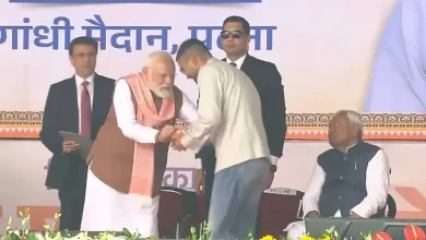 બિહારના મંત્રી દીપક પ્રકાશ શપથગ્રહણ સમારોહમાં ડેનિમ જીન્સ, શર્ટ અને ક્રોક્સ પહેરીને શપથ લઈ રહ્યા છે; બાજુમાં નીતીશ કુમાર અને અન્ય નેતાઓ.