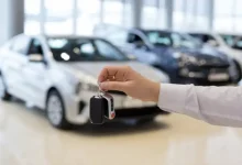 Passenger vehicles lined up at an automobile dealership representing growth in November sales.