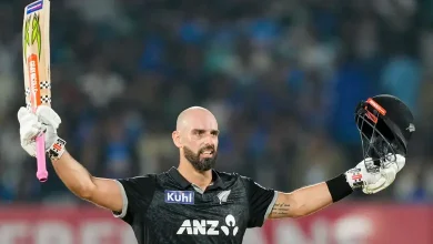 રાજકોટમાં ભારત સામે સદી ફટકાર્યા બાદ બેટ ઊંચું કરીને ઉજવણી કરતો ડેરિલ મિચલ.