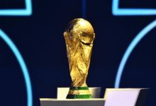 Fans cheering with flags during a football match, symbolizing World Cup fever.