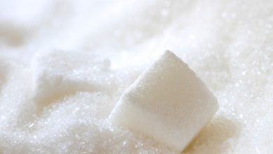 Large sacks of sugar in a wholesale warehouse representing market supply and demand.