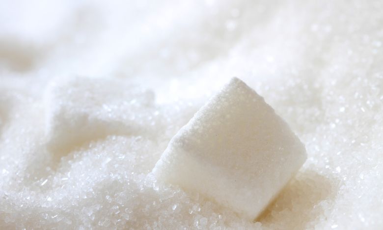 Large sacks of sugar in a wholesale warehouse representing market supply and demand.