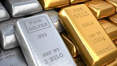 સોનાના સિક્કા અને ચાંદીની લગડીઓ સાથે ભાવમાં ઘટાડો દર્શાવતો ગ્રાફ.