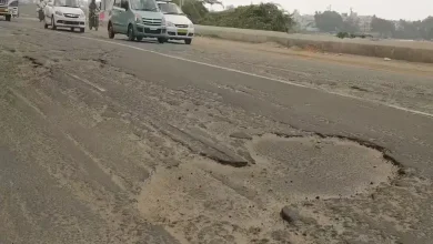 અમદાવાદના બિસ્માર રસ્તા અને ખાડાઓનું દ્રશ્ય જેમાં AMCના ભ્રષ્ટાચાર સામે વિરોધ પ્રદર્શિત થાય છે.