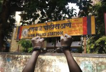 pair of sneakers next to a gold chain and handcuffs, representing the Sion arrest.