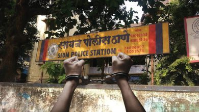 pair of sneakers next to a gold chain and handcuffs, representing the Sion arrest.